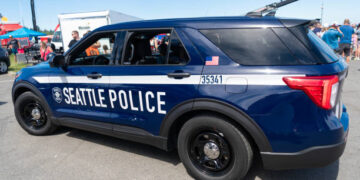 Seattle, WA, USA -July 3, 2024: Blue and white Seattle police car parked on street. Seattle state police